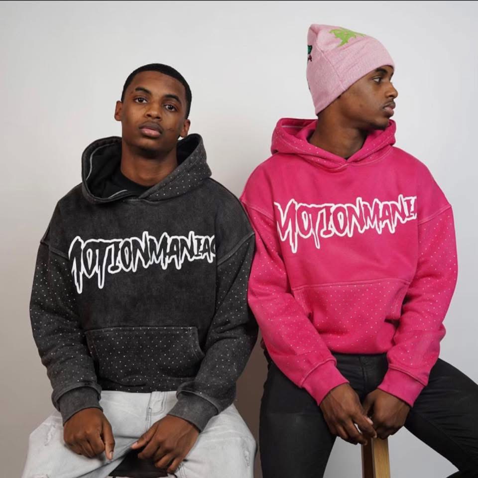80k Twins sitting side by side in Motion Maniac hoodies